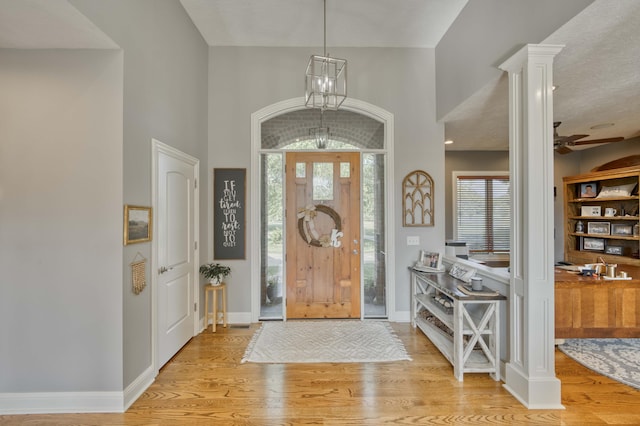 1865 N Hearthstone Ln, Strafford, MO 65757 - foyer entrance featuring light wood-style floors, baseboards, a ceiling fan, a towering ceiling, and ornate columns