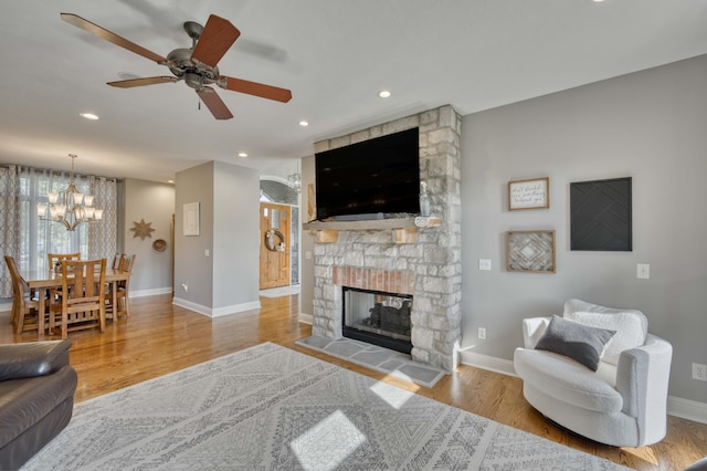 1865 N Hearthstone Ln, Strafford, MO 65757 - living area featuring baseboards, wood finished floors, a fireplace, a ceiling fan, and a chandelier