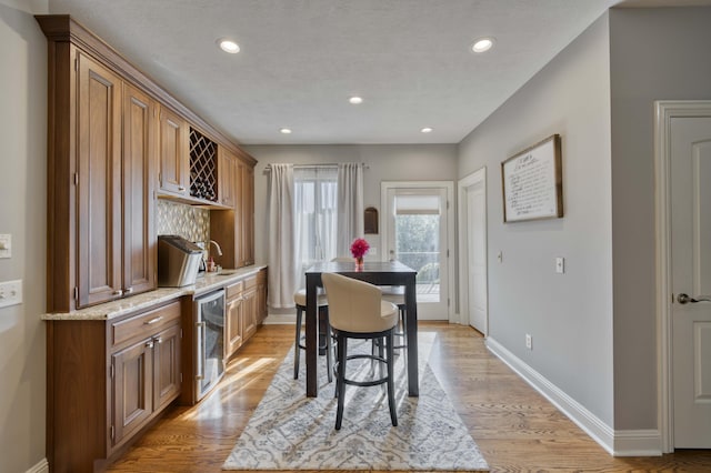 1865 N Hearthstone Ln, Strafford, MO 65757 - dining space featuring beverage cooler, baseboards, light wood-type flooring, recessed lighting, and bar area