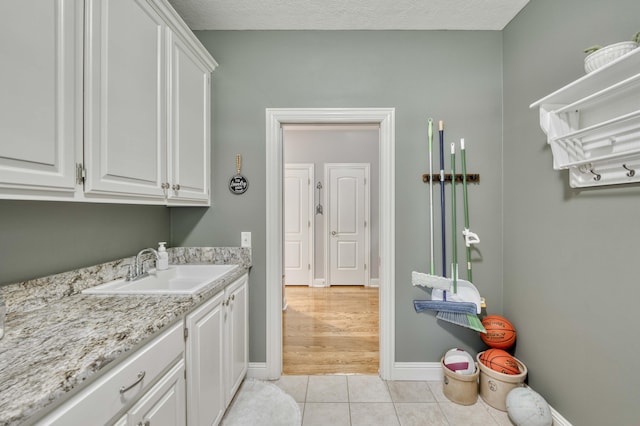 1865 N Hearthstone Ln, Strafford, MO 65757 - laundry area with a sink, light tile patterned floors, and baseboards