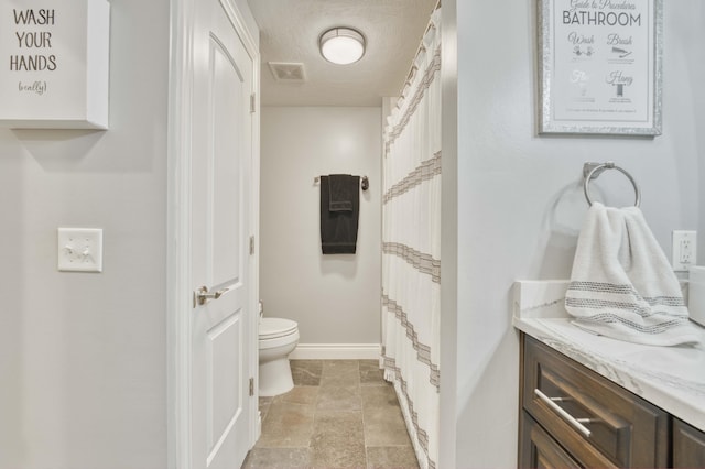 1865 N Hearthstone Ln, Strafford, MO 65757 - bathroom with toilet, vanity, baseboards, a textured ceiling, and stone finish flooring