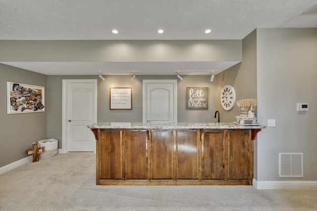 1865 N Hearthstone Ln, Strafford, MO 65757 - kitchen with light colored carpet, a peninsula, baseboards, light stone counters, and recessed lighting