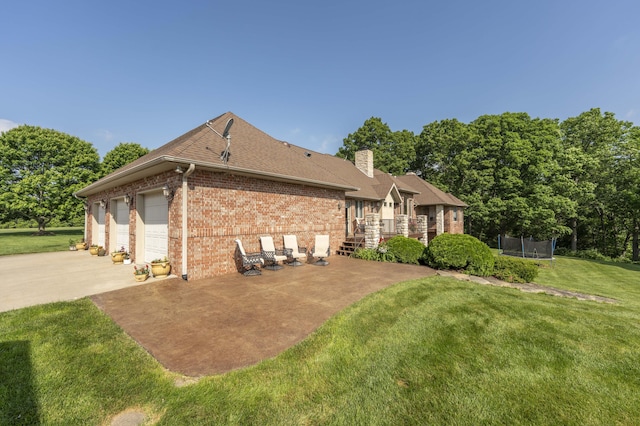 1865 N Hearthstone Ln, Strafford, MO 65757 - back of property featuring a trampoline, brick siding, concrete driveway, a lawn, and a chimney