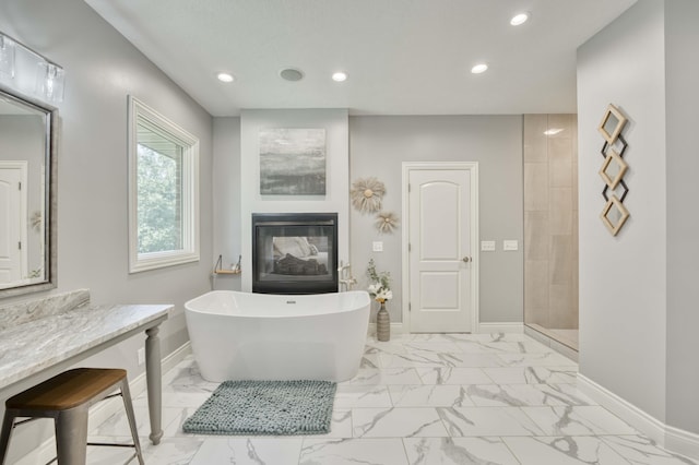 1865 N Hearthstone Ln, Strafford, MO 65757 - full bath featuring marble finish flooring, baseboards, recessed lighting, a soaking tub, and a multi sided fireplace