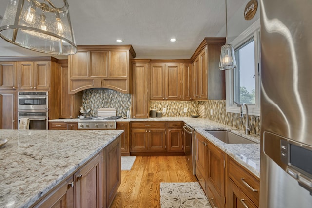 1865 N Hearthstone Ln, Strafford, MO 65757 - kitchen featuring stainless steel appliances, a sink, brown cabinetry, light wood finished floors, and recessed lighting
