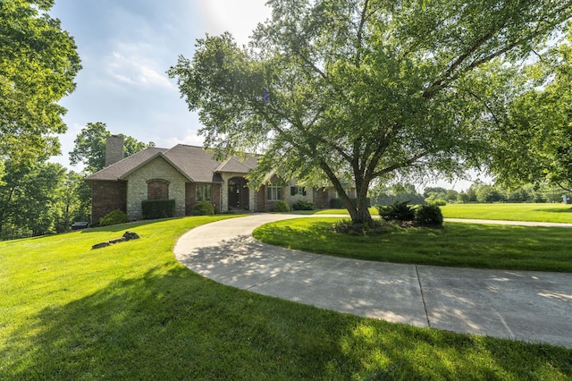 1865 N Hearthstone Ln, Strafford, MO 65757 - view of front of property with stone siding, a chimney, curved driveway, and a front yard