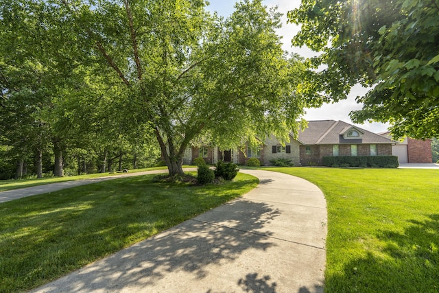 1865 N Hearthstone Ln, Strafford, MO 65757 - view of front facade featuring a front yard, brick siding, and curved driveway