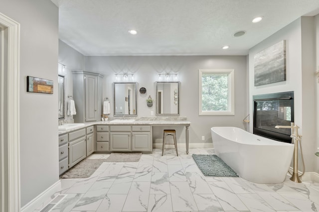 1865 N Hearthstone Ln, Strafford, MO 65757 - full bathroom featuring marble finish floors, a freestanding tub, double vanity, recessed lighting, and baseboards