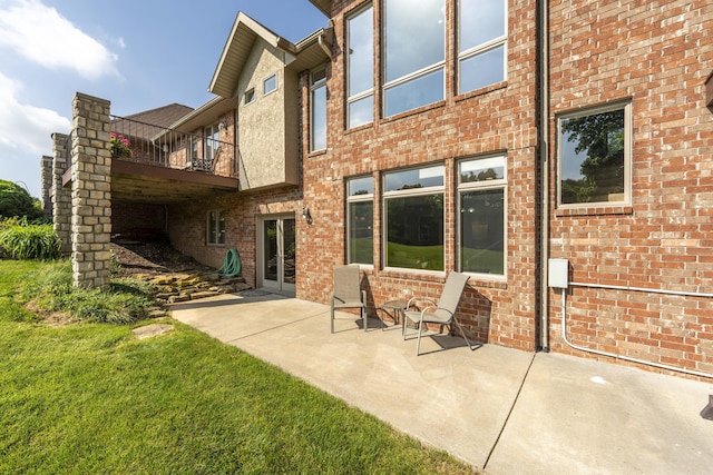 1865 N Hearthstone Ln, Strafford, MO 65757 - back of house featuring a balcony, a patio area, brick siding, and a yard