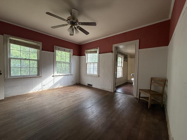 404 S 5th St, Thayer, MO 65791 - unfurnished room featuring wood finished floors, healthy amount of natural light, a ceiling fan, a wainscoted wall, and crown molding