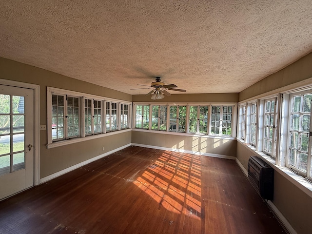 404 S 5th St, Thayer, MO 65791 - unfurnished sunroom with baseboards, a textured ceiling, wood-type flooring, a wall mounted AC, and plenty of natural light