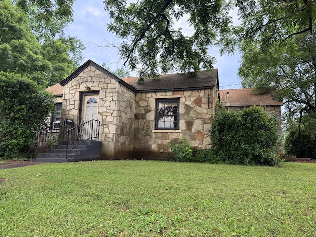 404 S 5th St, Thayer, MO 65791 - tudor house featuring stone siding, a front yard, and roof with shingles