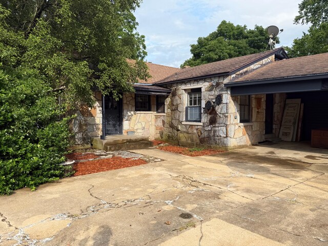 404 S 5th St, Thayer, MO 65791 - view of front of property featuring stone siding, concrete driveway, a shingled roof, and a carport