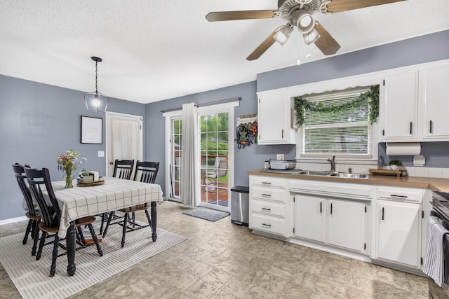 668 W Springfield St, Aurora, MO 65605 - kitchen featuring a sink, a textured ceiling, white cabinets, a ceiling fan, and hanging light fixtures