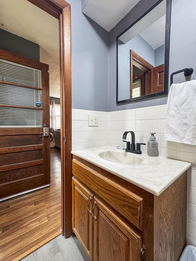 2052 N Grant Ave, Springfield, MO 65803 - bathroom with vanity, decorative backsplash, and wood finished floors