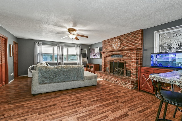 2052 N Grant Ave, Springfield, MO 65803 - living room with a ceiling fan, a textured ceiling, wood finished floors, a brick fireplace, and baseboards