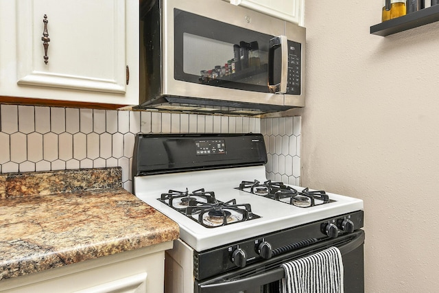 2052 N Grant Ave, Springfield, MO 65803 - kitchen with gas range gas stove, stainless steel microwave, backsplash, and white cabinets