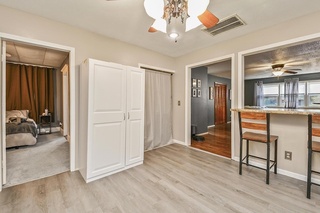 2052 N Grant Ave, Springfield, MO 65803 - kitchen with ceiling fan, light wood finished floors, a kitchen bar, and baseboards