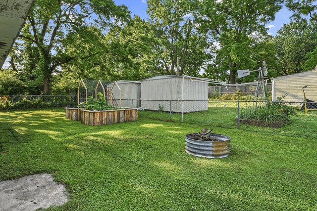 2052 N Grant Ave, Springfield, MO 65803 - view of yard featuring a garden, an outdoor structure, and view of wooded area