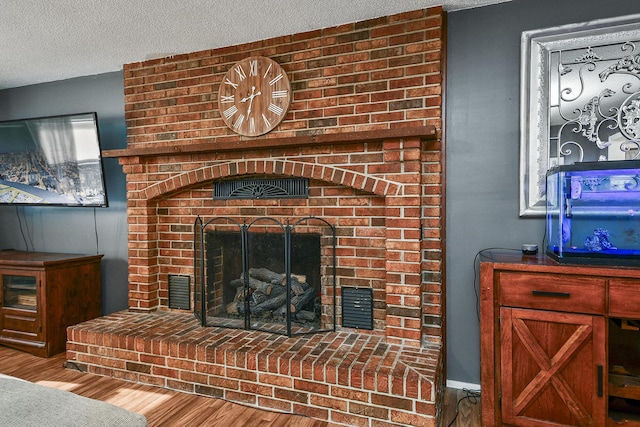 2052 N Grant Ave, Springfield, MO 65803 - detailed view of a brick fireplace, wood finished floors, and a textured ceiling
