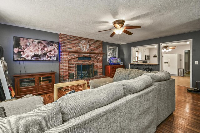 2052 N Grant Ave, Springfield, MO 65803 - living room with ceiling fan, a textured ceiling, wood finished floors, and a fireplace