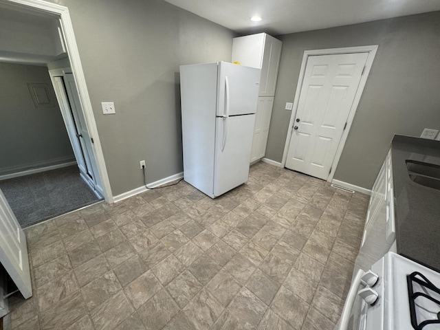 2152 E Cairo St, Springfield, MO 65802 - kitchen featuring freestanding refrigerator, baseboards, white cabinets, stone finish floors, and recessed lighting