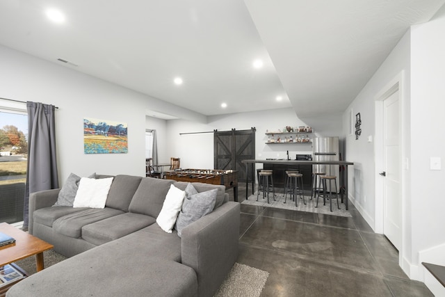 7015 Calabash St, Nixa, MO 65714 - living area with a barn door, finished concrete floors, bar area, recessed lighting, and baseboards