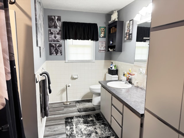 27641 County Road 356, Pittsburg, MO 65724 - bathroom with tile walls, vanity, toilet, a wainscoted wall, and wood finished floors