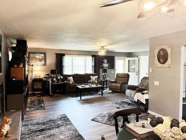 27641 County Road 356, Pittsburg, MO 65724 - living room with a ceiling fan, a textured ceiling, wood finished floors, and a chandelier
