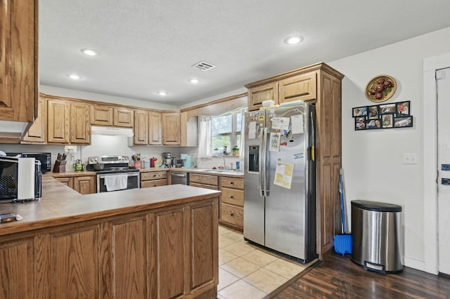 1142 Rte F, Anderson, MO 64831 - kitchen featuring stainless steel appliances, under cabinet range hood, a peninsula, a sink, and recessed lighting