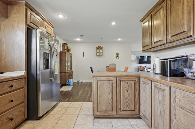 1142 Rte F, Anderson, MO 64831 - kitchen featuring stainless steel refrigerator with ice dispenser, a peninsula, recessed lighting, light tile patterned floors, and brown cabinetry