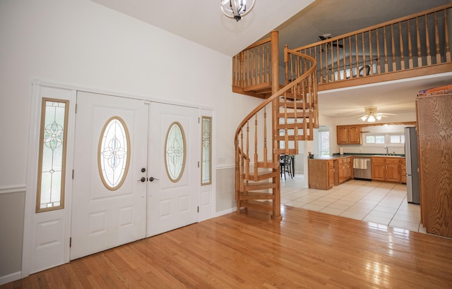 1603 W Northwood St, Bolivar, MO 65613 - foyer entrance with a high ceiling, stairs, light wood finished floors, a ceiling fan, and baseboards