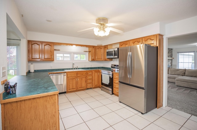 1603 W Northwood St, Bolivar, MO 65613 - kitchen featuring stainless steel appliances, a sink, a ceiling fan, dark countertops, and light tile patterned floors