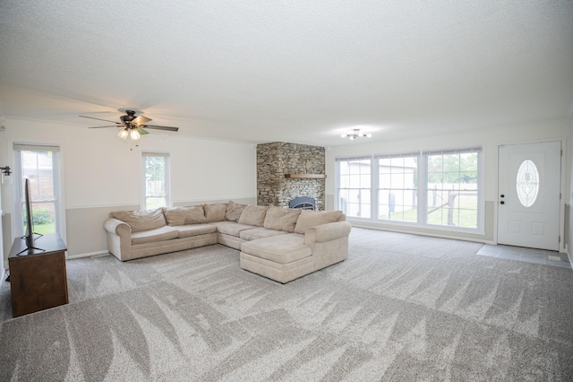 1603 W Northwood St, Bolivar, MO 65613 - carpeted living area featuring ceiling fan, a stone fireplace, and a textured ceiling