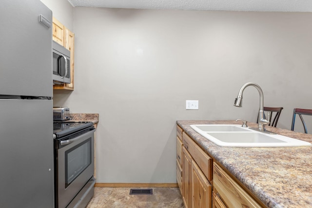 550 Notch Ln Unit 2, Reeds Spring, MO 65737 - kitchen with stainless steel appliances, a sink, light brown cabinets, and light countertops