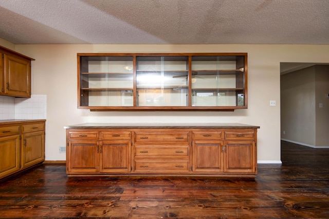 801 N 11th Ave, Ozark, MO 65721 - kitchen with dark wood-style floors, brown cabinets, tasteful backsplash, a textured ceiling, and baseboards