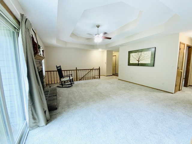 540 S Hickory Dr, Springfield, MO 65809 - empty room with a tray ceiling, light carpet, a ceiling fan, baseboards, and a fireplace