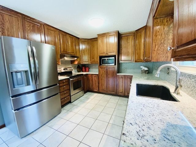540 S Hickory Dr, Springfield, MO 65809 - kitchen with stainless steel appliances, under cabinet range hood, a sink, decorative backsplash, and light tile patterned floors