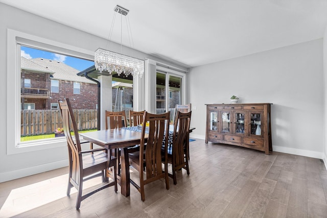 518 N Dublin Dr, Nixa, MO 65714 - dining area featuring a chandelier, wood finished floors, and baseboards