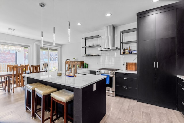 518 N Dublin Dr, Nixa, MO 65714 - kitchen featuring gas range, wall chimney range hood, dark cabinets, modern cabinets, and light wood-type flooring