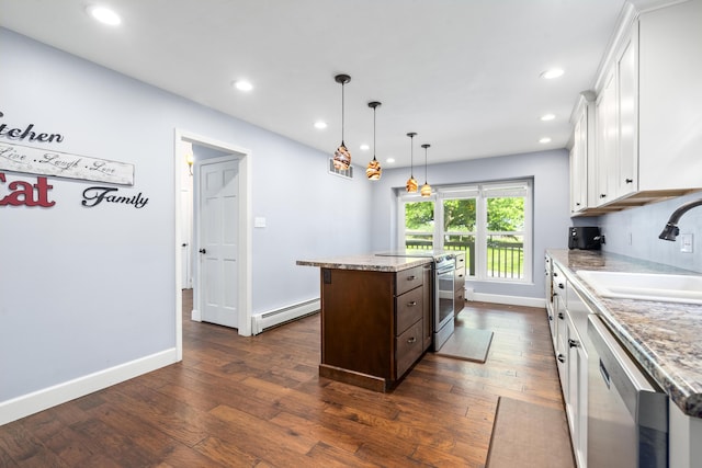 4159 N Farm Rd Unit 173, Springfield, MO 65803 - kitchen featuring appliances with stainless steel finishes, baseboard heating, a sink, a kitchen island, and white cabinets