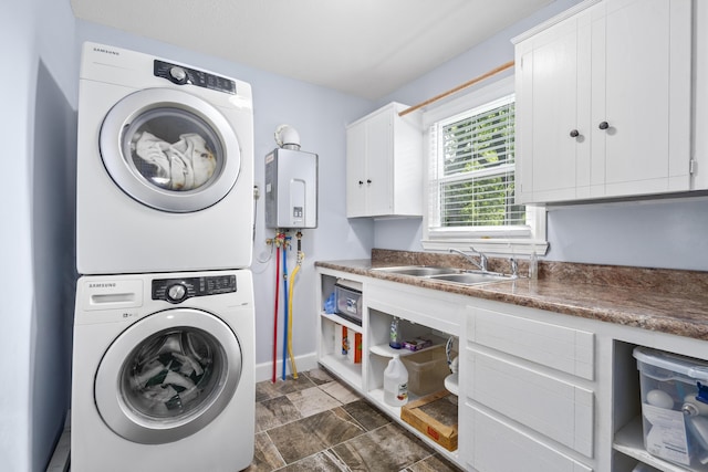 4159 N Farm Rd Unit 173, Springfield, MO 65803 - washroom with stacked washer / dryer, cabinet space, tankless water heater, baseboards, and dark stone finish flooring