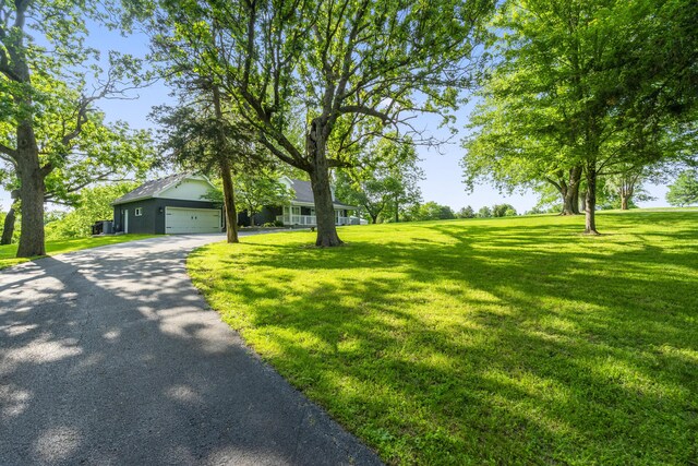 4159 N Farm Rd Unit 173, Springfield, MO 65803 - view of front facade featuring asphalt driveway, a front lawn, and a garage