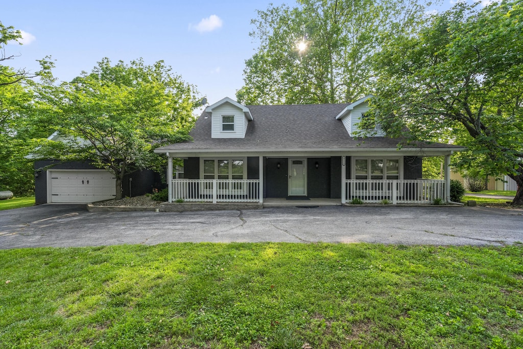 4159 N Farm Rd Unit 173, Springfield, MO 65803 - view of front of home featuring a porch, asphalt driveway, and a front lawn