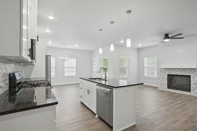 406 Barton Pl, Neosho, MO 64850 - kitchen featuring a glass covered fireplace, appliances with stainless steel finishes, a sink, open floor plan, and wood finished floors