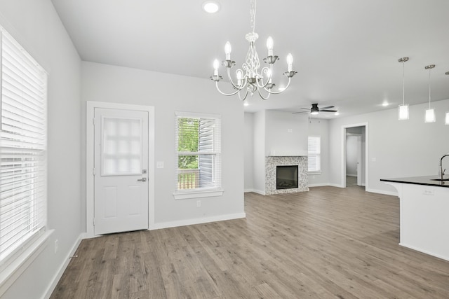 406 Barton Pl, Neosho, MO 64850 - unfurnished living room with plenty of natural light, ceiling fan, wood finished floors, and a chandelier