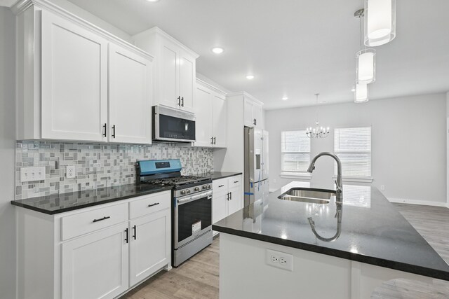 406 Barton Pl, Neosho, MO 64850 - kitchen featuring appliances with stainless steel finishes, a sink, backsplash, white cabinets, and light wood-style flooring