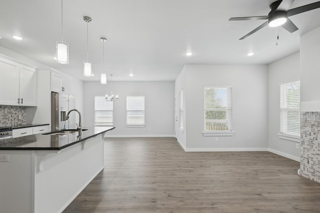 406 Barton Pl, Neosho, MO 64850 - kitchen with dark countertops, fridge with ice dispenser, a chandelier, white cabinetry, and recessed lighting