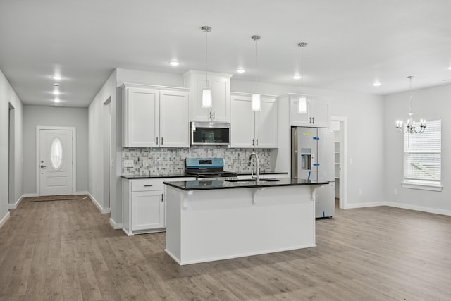 406 Barton Pl, Neosho, MO 64850 - kitchen with stainless steel appliances, a sink, dark countertops, baseboards, and light wood finished floors