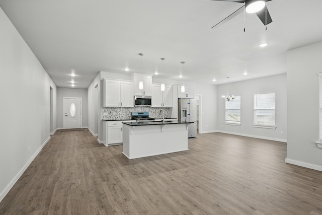 406 Barton Pl, Neosho, MO 64850 - kitchen with appliances with stainless steel finishes, ceiling fan, open floor plan, a chandelier, and baseboards